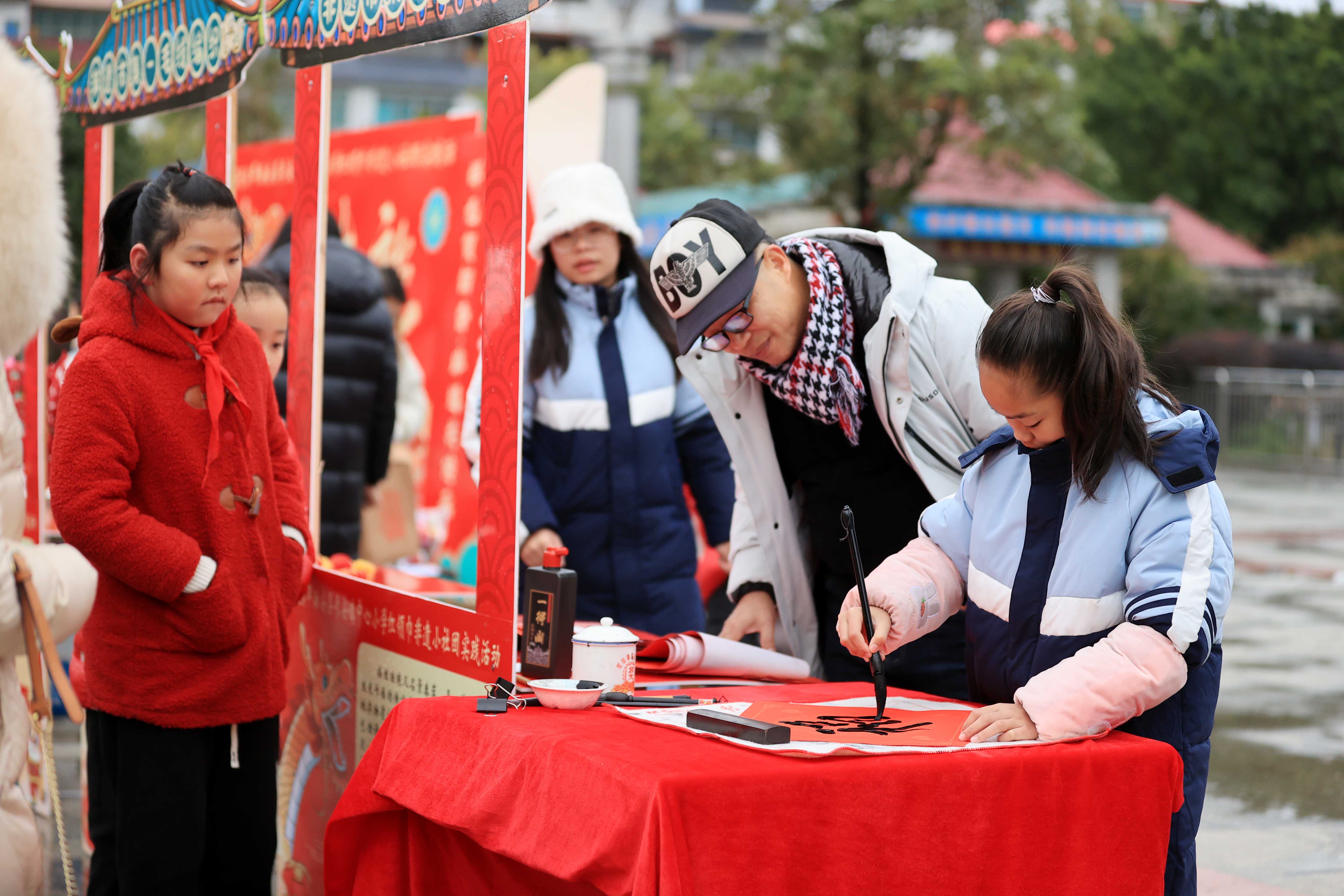 圖10：1月20日，在廣西柳州市融安縣長安廣場，一名小學生在書寫福字，準備贈送市民。（譚凱興 攝）.JPG