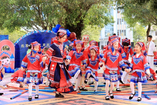 圖4：4月9日，在廣西柳州市融安縣實驗小學校園，一名老師帶著學生跳竹竿舞。（譚凱興 攝）.JPG