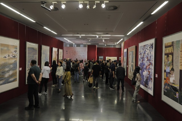參觀者駐足欣賞中小學美術教師作品。活動方供圖 .jpg